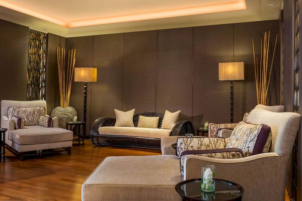 Lobby-Lounge im Siam Kempinski Hotel Bangkok mit modernen Möbeln und braunen Wänden.