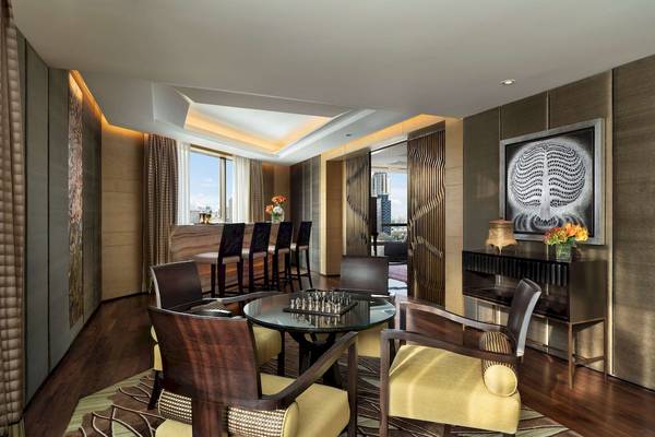 Innenraum des Siam Kempinski Hotels in Bangkok mit Bar, Esstisch und Kunstwerk.