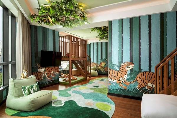 Kinderzimmer im Siam Kempinski Hotel Bangkok mit Tiger-Motiv an den Wänden und Holztreppe.