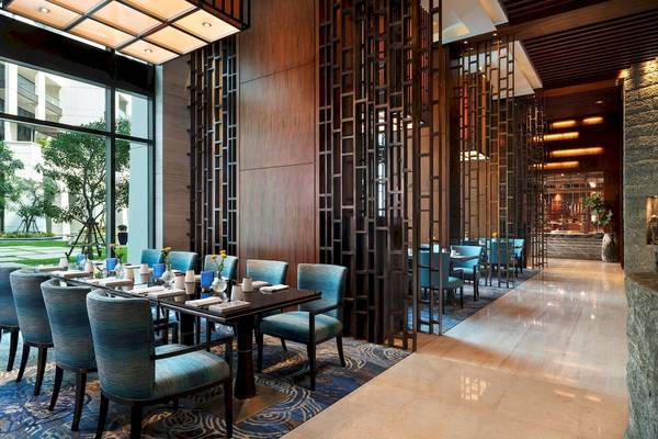 Innenbereich des Speisesaals im Siam Kempinski Hotel Bangkok mit blauen Stühlen und Tisch.