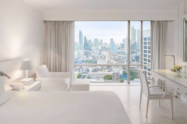 Innenansicht eines eleganten Zimmers im Pullman Bangkok Hotel G mit Blick auf die Stadt