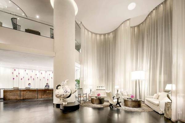 Lobby des Pullman Bangkok Hotel G mit weißen Vorhängen und modernem Interieur.