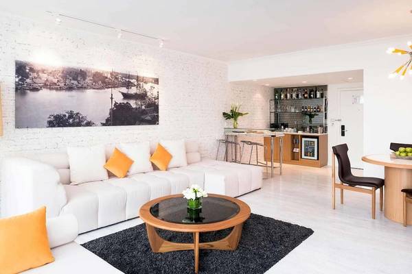 Innenbereich des Pullman Bangkok Hotel G mit weißer Couch, Couchtisch und Bar.
