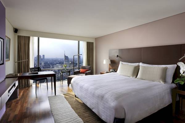 Ein elegantes Hotelzimmer im Pullman Bangkok Hotel G mit Blick auf die Stadt.