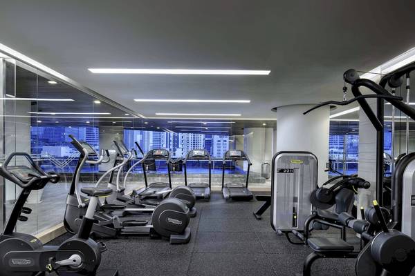 Fitnesscenter im Pullman Bangkok Hotel G mit verschiedenen Geräten und Ausblick auf die Stadt.
