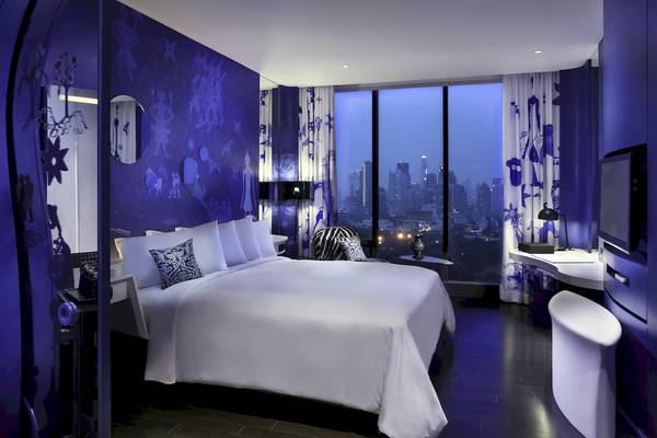 Zimmer im SO/ Bangkok Hotel mit einem großen Bett und einem Blick auf die Stadt.