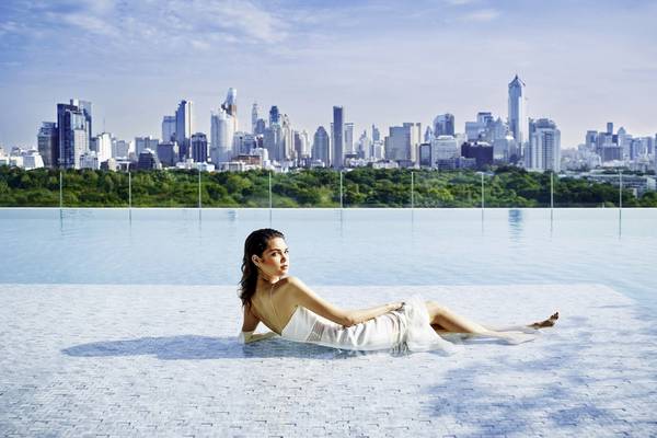 Frau im Pool vor der Stadtlandschaft des SO/ Bangkok