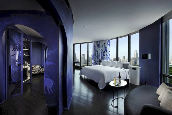 Innenansicht des Schlafzimmers im SO/ Bangkok Hotel mit Blick auf die Stadt.