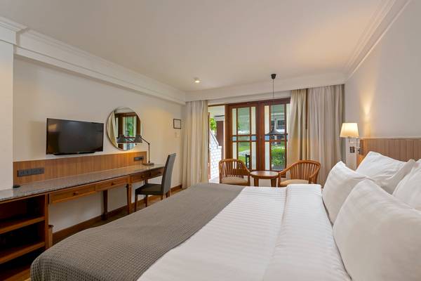 Hotelzimmer im Sunprime Kamala Beach mit Fernseher, Schreibtisch und Balkonzugang.
