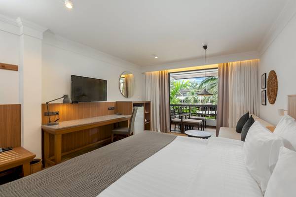 Hotelzimmer im Sunprime Kamala Beach mit Bett, Schreibtisch, Fernseher und Balkon.