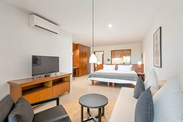 Hotelzimmer im Sunprime Kamala Beach mit Fernseher, Bett, Couch und Tisch.