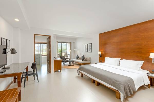 Innenansicht eines Zimmers im Sunprime Kamala Beach Hotel mit Doppelbett, Schreibtisch und Fernseher.