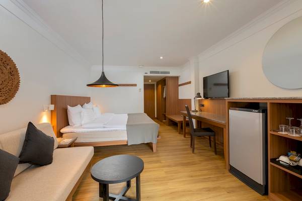 Hotelzimmer im Sunprime Kamala Beach mit Bett, Schreibtisch und Fernseher.