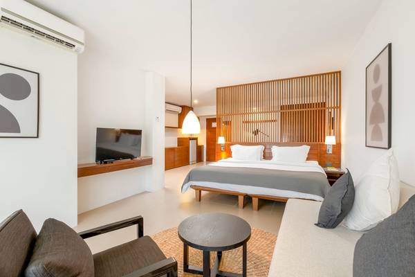 Hotelzimmer im Sunprime Kamala Beach mit Fernseher, Bett und Wohnzimmermöbeln.