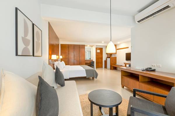Hotelzimmer im Sunprime Kamala Beach mit Bett, Sofa, Tisch und Klimaanlage.