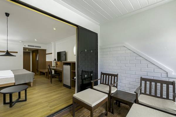 Innenansicht eines Hotelzimmers im Sunprime Kamala Beach mit Bett, Schreibtisch und Möbeln.