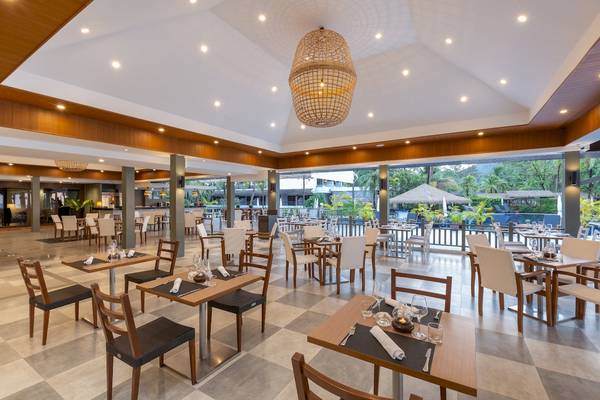 Innenbereich des Sunprime Kamala Beach Restaurants mit runden Tischen und Stühlen.