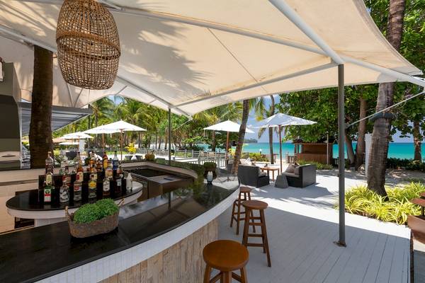 Außenbereich des Sunprime Kamala Beach Hotels mit Bar, Stühlen und Blick auf den Strand.
