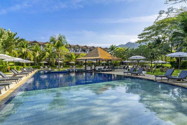 Außenpoolbereich des Sunprime Kamala Beach Hotels mit Loungeliegen und Sonnenschirmen.