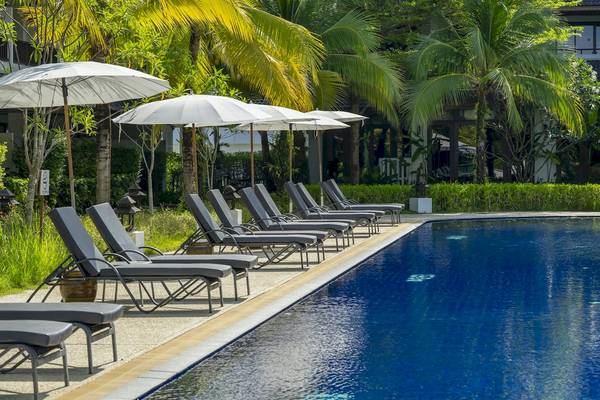 Pool mit Liegestühlen und Schirmen im Sunprime Kamala Beach Hotel.