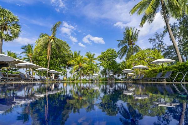Ein Hotelpool mit Sonnenschirmen und Palmenbäumen am Sunprime Kamala Beach.