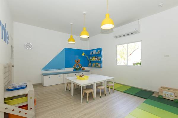 Kinderzimmer im Sunwing Bangtao Beach Hotel mit blauen und weißen Wänden, gelben Lampen und einer Bücherwand.