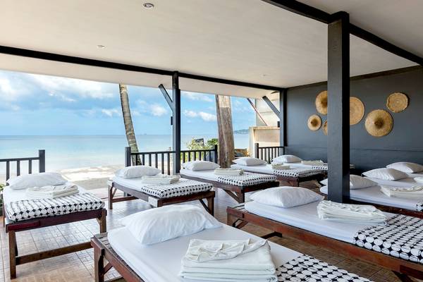 Terrasse des Sunwing Bangtao Beach Hotels mit mehreren Betten, Blick auf den Ozean.