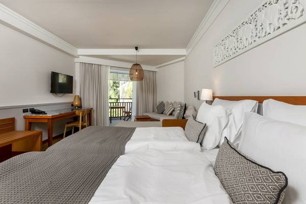Doppelbettzimmer im Sunwing Bangtao Beach Hotel mit Fernseher und Balkonzugang.