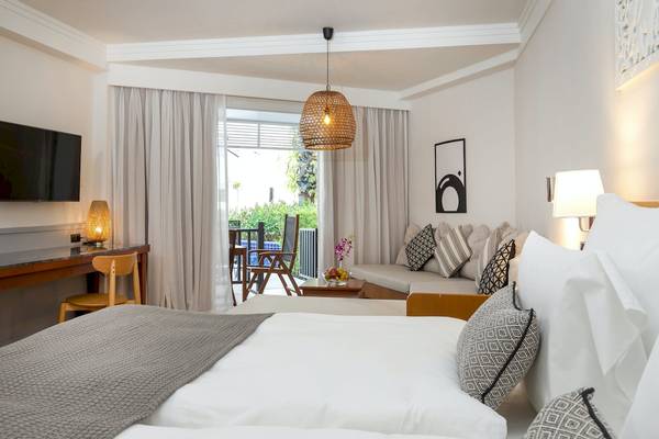 Doppelzimmer im Sunwing Bangtao Beach Hotel mit Fernseher, Bett, Wohnzimmerecke und Balkonzugang.