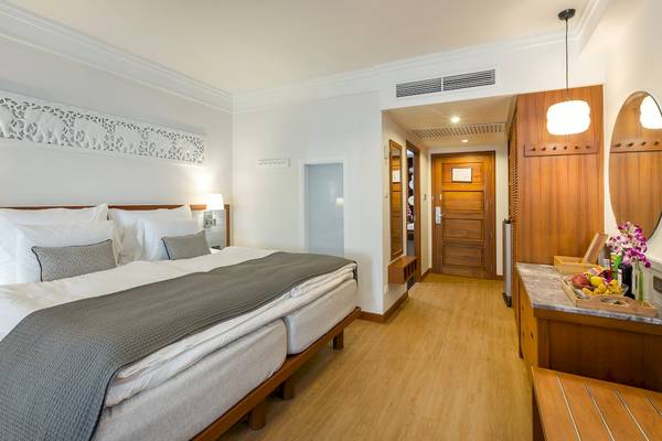 Doppelbett im Sunwing Bangtao Beach Hotelzimmer mit weißen Laken und Kissen.