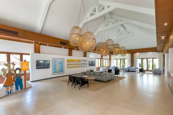 Innenbereich des Hoteleingangs von Sunwing Bangtao Beach mit Lampen, Sofas und Dekor.