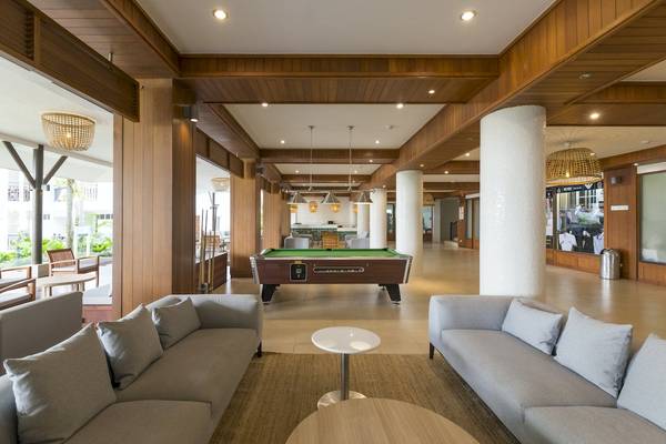 Lobbybereich des Sunwing Bangtao Beach Hotels mit Billardtisch und Sofas.