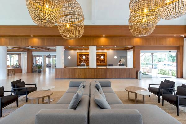 Lobby des Sunwing Bangtao Beach Hotels mit Rezeption, Sofas und Holzlampen