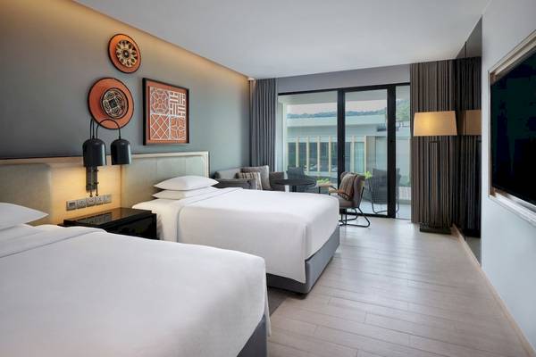 Doppelbett-Zimmer im Four Points by Sheraton Phuket Patong Beach Resort mit Balkon und Blick auf die Berge.