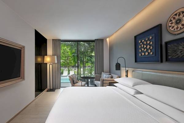 Schlafzimmer im Four Points by Sheraton Phuket Patong Beach Resort mit großem Bett und Blick auf den Pool.