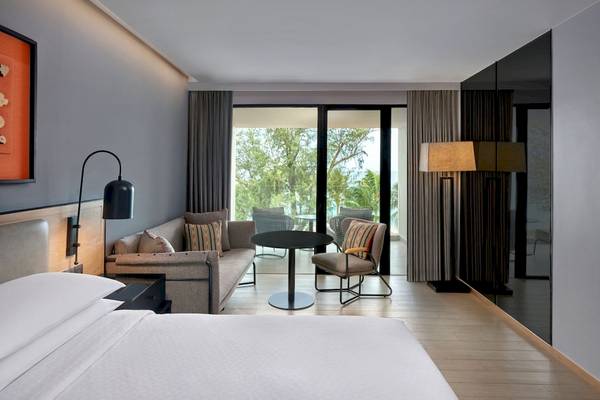 Schlafzimmer im Four Points by Sheraton Phuket Patong Beach Resort mit Bett, Couch, Tisch und Aussicht