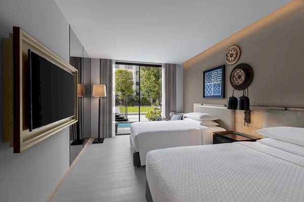 Doppelzimmer im Four Points by Sheraton Phuket Patong Beach Resort mit zwei Betten, Fernseher und Gartenblick.