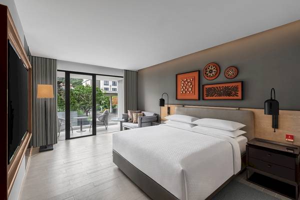Schlafzimmer im Four Points by Sheraton Phuket Patong Beach Resort mit Bett, Fernseher und Terrassenzugang.