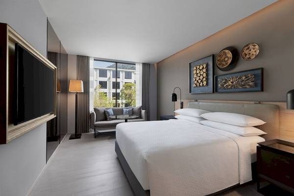 Schlafzimmer des Four Points by Sheraton Phuket Patong Beach Resort mit großem Bett und Fenstern.