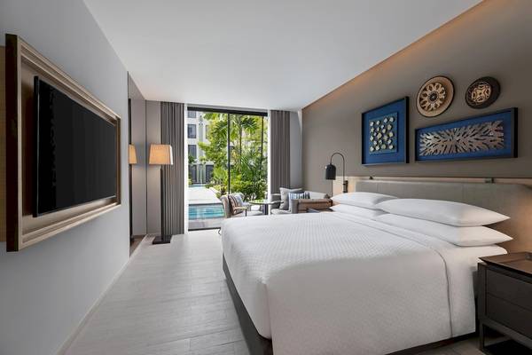 Hotelzimmer im Four Points by Sheraton Phuket Patong Beach Resort mit Swimmingpool im Hintergrund.
