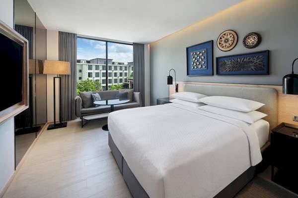 Ein modernes Hotelzimmer mit einem großen Bett und Sofa mit Blick auf die Stadt.