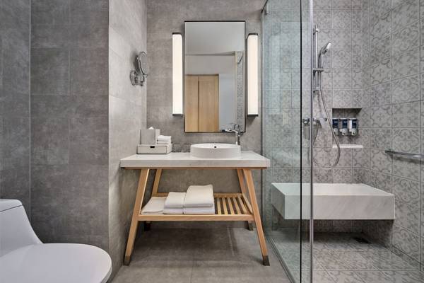 Badezimmer im Four Points by Sheraton Phuket Patong Beach Resort mit einer weißen Theke und einem modernen Design.