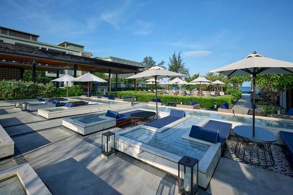 Außenpool des Four Points by Sheraton Phuket Patong Beach Resort mit Sonnenliegen und Sonnenschirmen