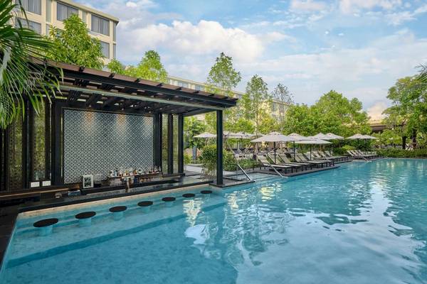 Außenpool des Four Points by Sheraton Phuket Patong Beach Resort mit Sonnenliegen und Schirmen