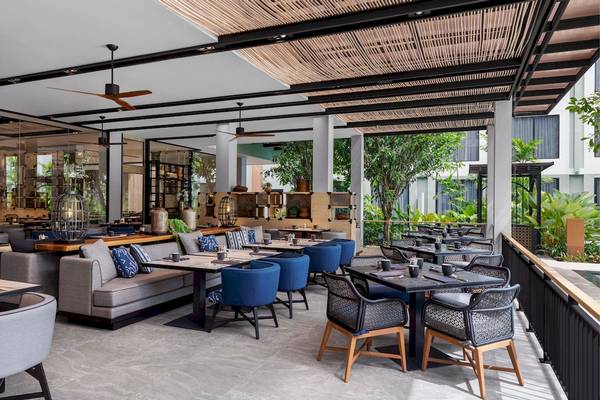 Restaurantbereich des Four Points by Sheraton Phuket Patong Beach Resort mit blauen Stühlen und Tischen.