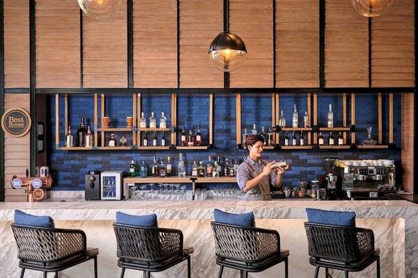 Ein Barkeeper im Four Points by Sheraton Phuket Patong Beach Resort serviert ein Getränk.