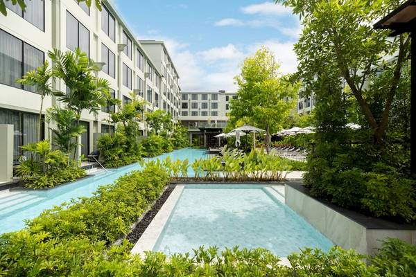 Vier Punkte Sheraton Phuket Patong Beach Resort mit Außenpool und grüner Landschaft.