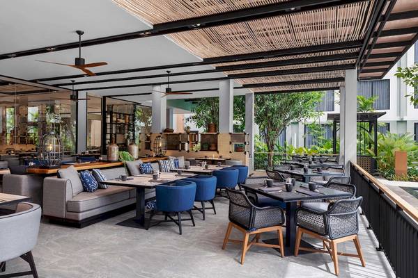 Vier Punkte Sheraton Phuket Patong Strand Restaurant Innenansicht mit Tischen und Stühlen.
