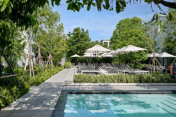 Außenbereich des Four Points by Sheraton Phuket Patong Beach Resorts mit Swimmingpool, Sonnenliegen und Sonnenschirmen.