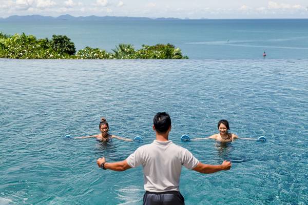 Schwimmtraining im Außenpool des Amatara Welleisure Resorts mit Blick auf das Meer.